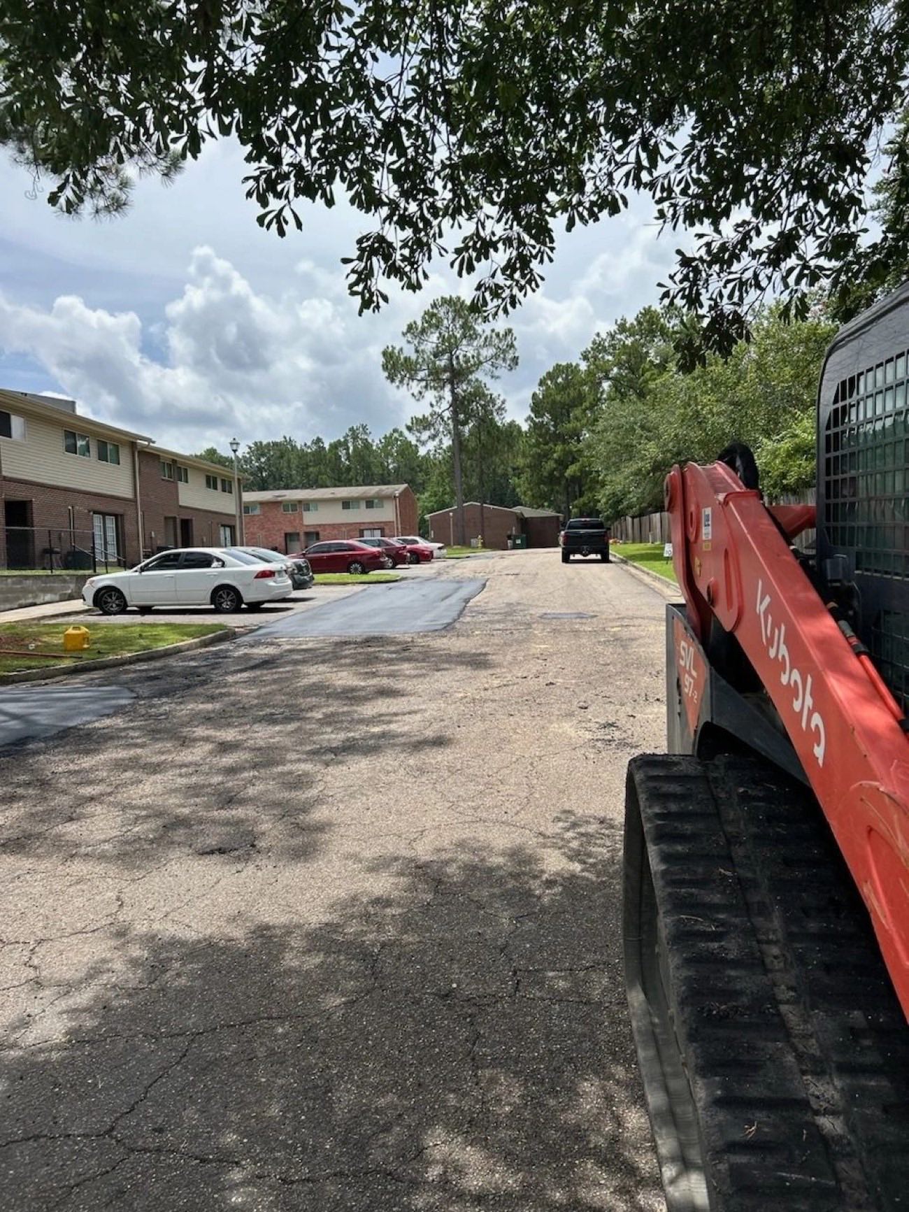 Gulfline Paving crew with excavator finishing a fresh asphalt surface